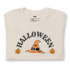 Beige t-shirt with a simple Halloween design featuring a witch hat and pumpkins, perfect for spooky season celebrations.