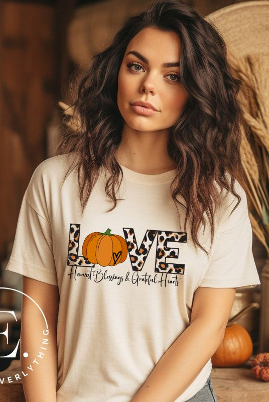 Spread love and autumn vibes with our trendy t-shirt. Featuring the word 'love' in cheetah print with a pumpkin as the 'o,' and "Harvest Blessings and Grateful Hearts' underneath on a soft cream shirt. 
