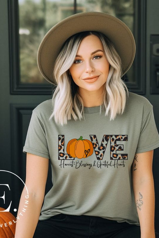 Spread love and autumn vibes with our trendy t-shirt. Featuring the word 'love' in cheetah print with a pumpkin as the 'o,' and "Harvest Blessings and Grateful Hearts' underneath on a green shirt. 