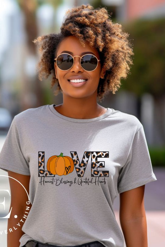 Spread love and autumn vibes with our trendy t-shirt. Featuring the word 'love' in cheetah print with a pumpkin as the 'o,' and "Harvest Blessings and Grateful Hearts' underneath on a grey shirt. 