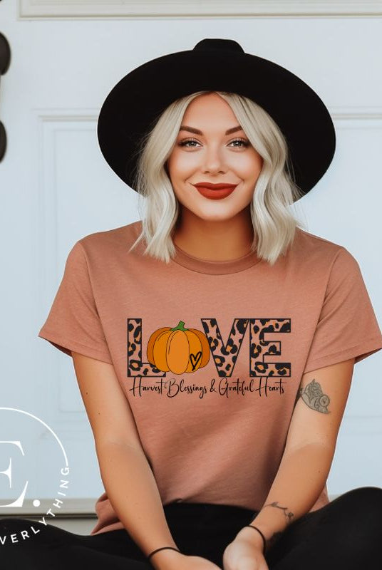 Spread love and autumn vibes with our trendy t-shirt. Featuring the word 'love' in cheetah print with a pumpkin as the 'o,' and "Harvest Blessings and Grateful Hearts' underneath on a mauve shirt. 