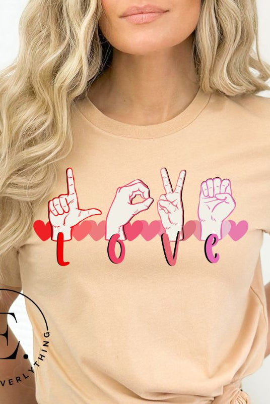 Beautiful ASL hand gesture spelling out love with hearts on a soft cream colored shirt.