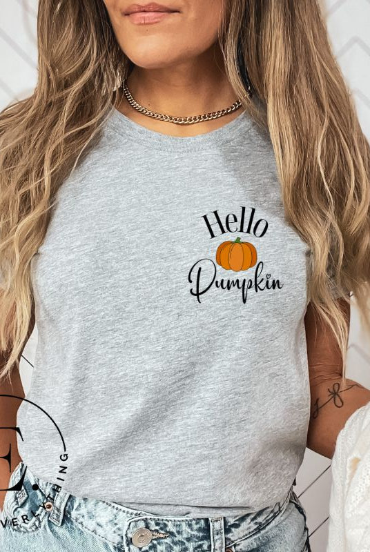 Say hello to autumn with our adorable t-shirt. It features a pumpkin on the front pocket and the playful phrase 'Hello Pumpkin,' this design captures the spirit of the season on a grey shirt. 