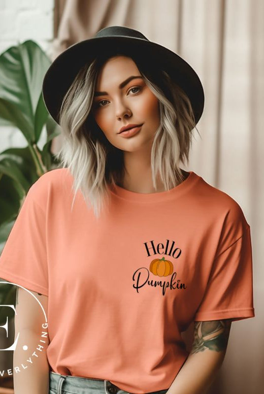 Say hello to autumn with our adorable t-shirt. It features a pumpkin on the front pocket and the playful phrase 'Hello Pumpkin,' this design captures the spirit of the season on a peach shirt. 