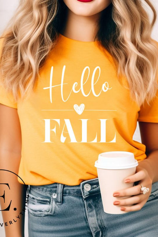 Hello Fall with heart between Hello and Fall graphic tee on a mustard shirt.