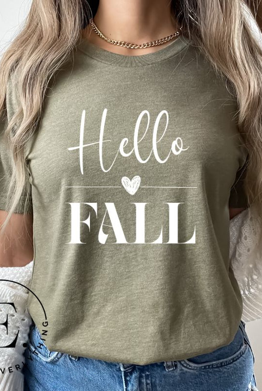 Hello Fall with heart between Hello and Fall graphic tee on a green shirt.