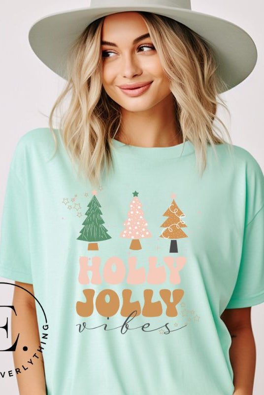 Get ready to feel the holly jolly vibes with our Christmas shirt! This festive shirt features a playful message that reads "Holly Jolly Vibes" and is adorned with cheerful Christmas trees, radiating the holiday cheer on a mint shirt.