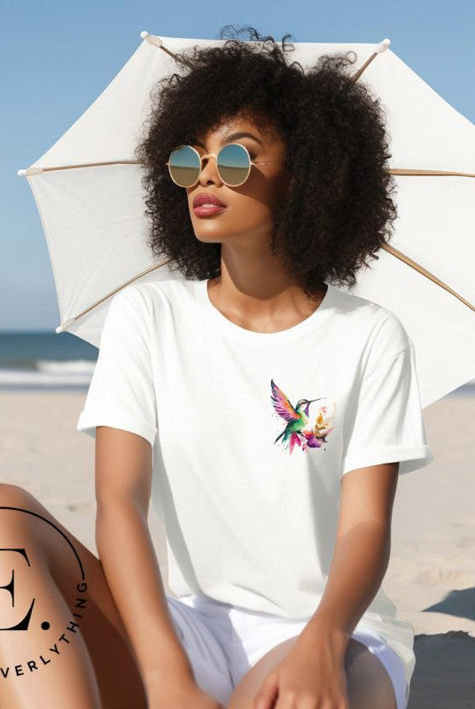 Elevate your style with our stunning t-shirt featuring a watercolor hummingbird delicately placed on the pocket on a white shirt. 