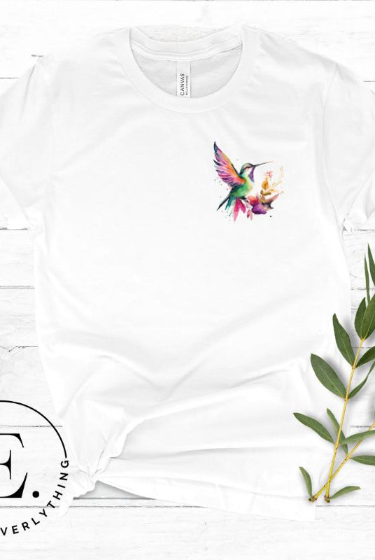 Elevate your style with our stunning t-shirt featuring a watercolor hummingbird delicately placed on the pocket on a white shirt. 