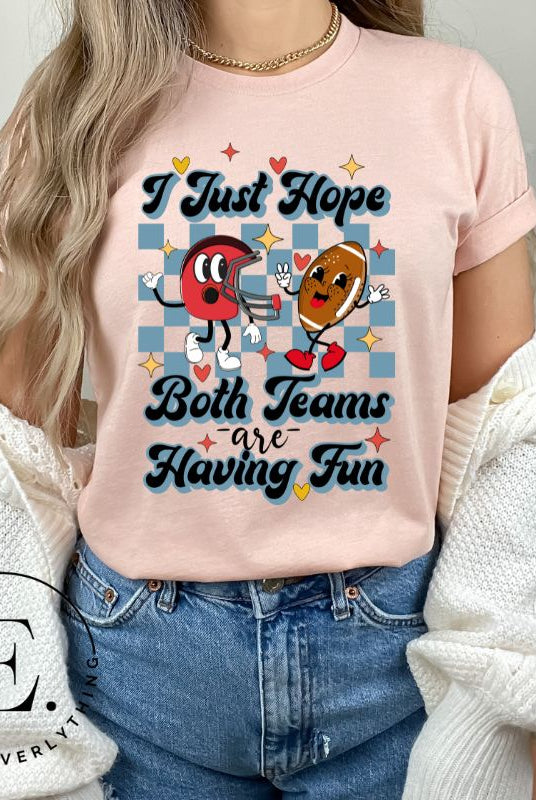 Dress in game day spirit with our Bella Canvas 3001 unisex tee! Featuring a retro design and the fun mantra, "I just hope both teams are having fun," on a heather prism peach shirt. 