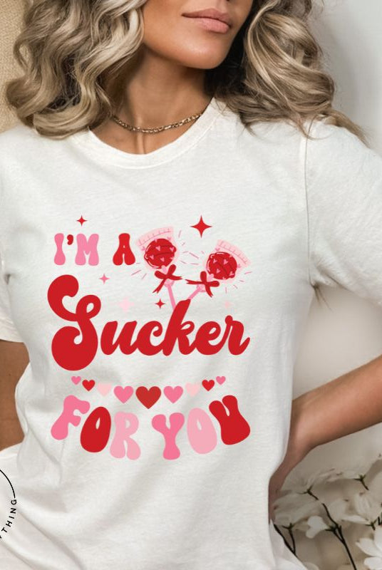 Indulge in the spirit of love with our Valentine's Day shirt! Adorned with charming Valentine lollipops and the playful saying, "I'm a sucker for you," on a white shirt. 