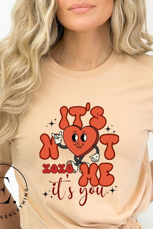Celebrate Valentine's with our playful shirt! Featuring a bold heart and the message "It's not me, it's you," on a tan shirt. 