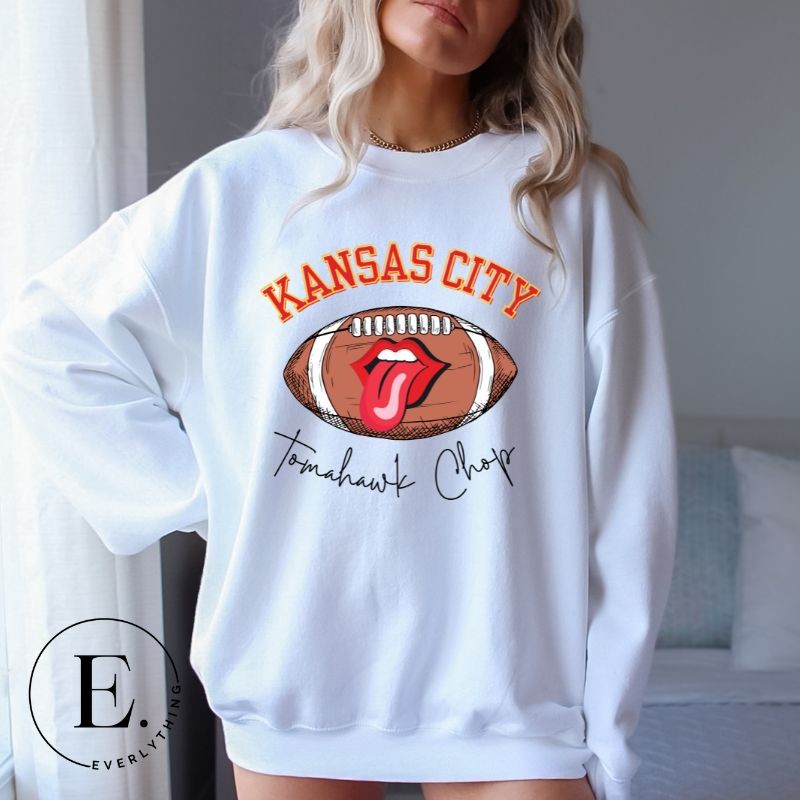 Show off your Kansas City pride with our exclusive sweatshirt that features the team's name and the spirited slogan, "Tomahawk Chop." ON a white sweatshirt. 