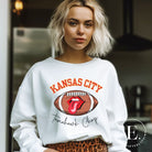 Show off your Kansas City pride with our exclusive sweatshirt that features the team's name and the spirited slogan, "Tomahawk Chop." On a white sweatshirt. 
