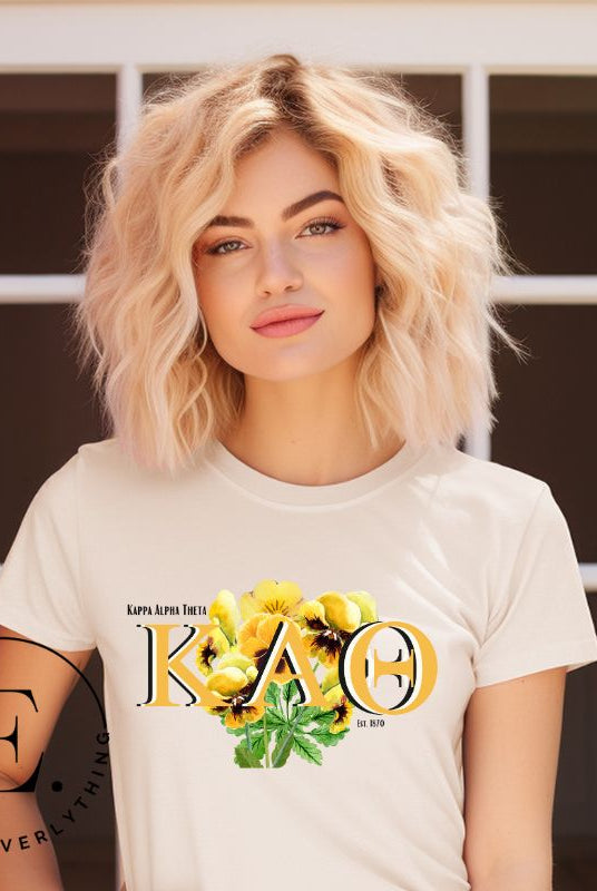Show your Kappa Alpha Theta pride with our sorority t-shirt! Our design features the sorority letters and a striking black and gold pansy, symbolizing sisterhood and strength on a soft cream shirt. 