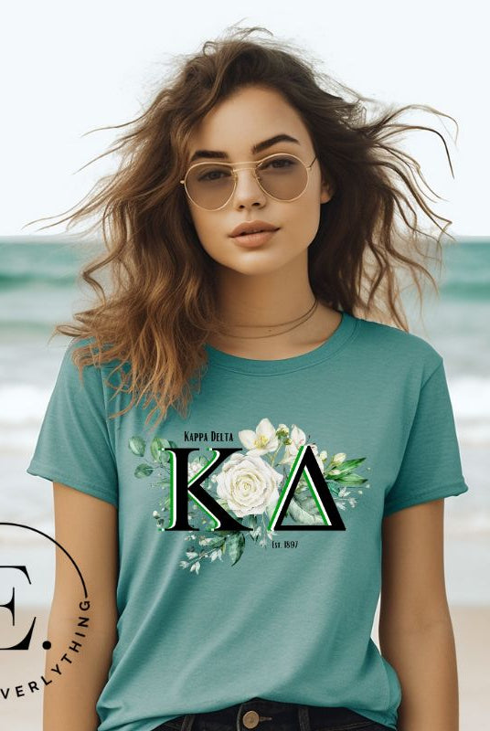 Elevate your Kappa Delta sisterhood with our stunning t-shirt, featuring the sorority letters and the elegant white rose  on a teal shirt. 
