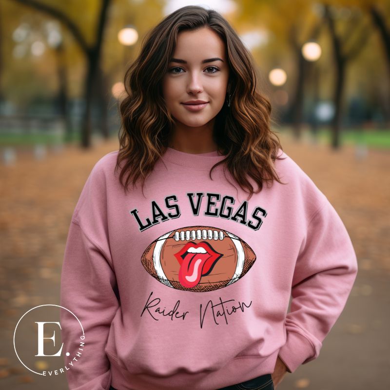 Get ready to support the Las Vegas Raiders in style with our premium sweatshirt, featuring the team's name and iconic slogan, "Raider Nation." On a pink sweatshirt. 