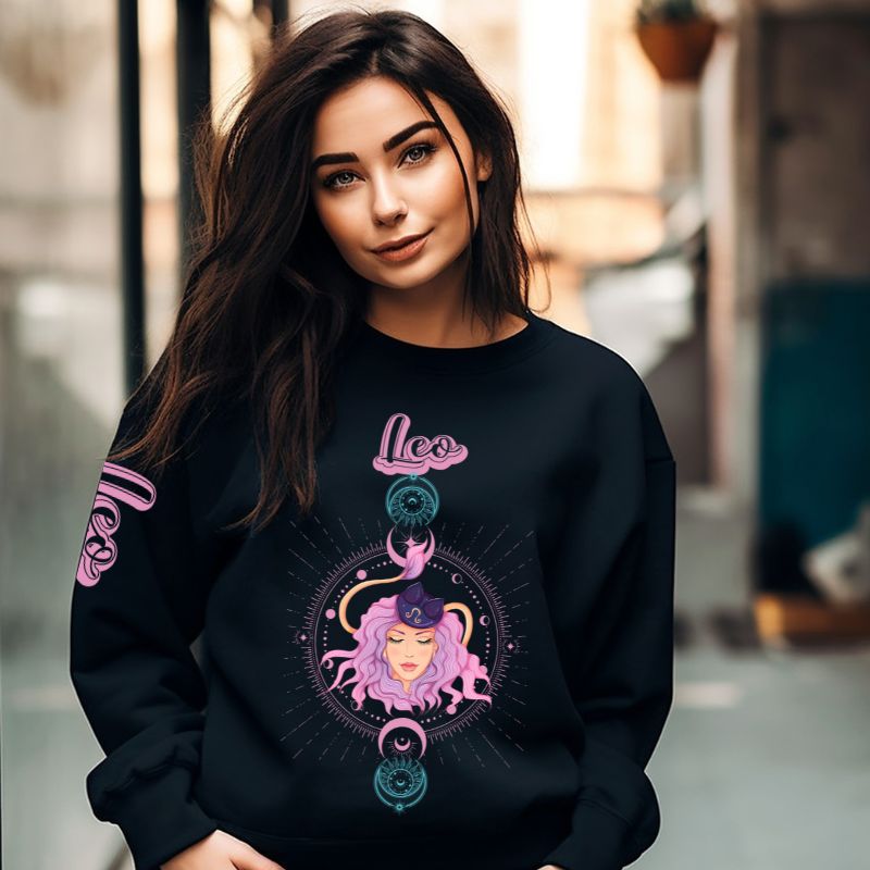 Gildan crewneck pullover sweatshirt featuring a pastel illustration of a Leo figure with flowing purple hair, surrounded by celestial elements. The word "Leo" is written in pink on the sleeve, adding a stylish touch on a black sweatshirt.