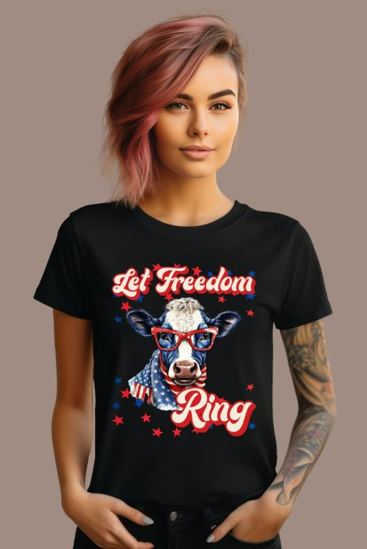 Graphic of a cow wearing sunglasses and a USA-themed scarf, with the text 'Let Freedom Ring' on the front of a black graphic tee.