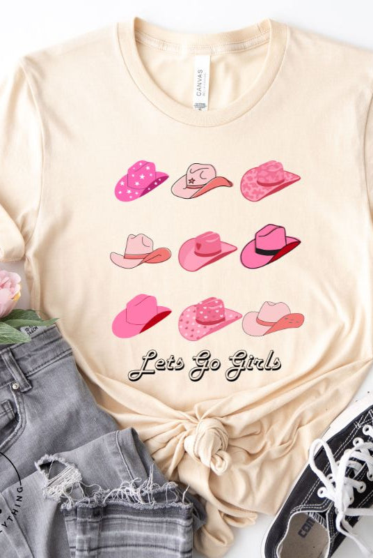 Get ready to wrangle in style with our country western shirt collection. Featuring a variety of pink cowboy hats and the classic phrase "Let's Go Girls," on a cream shirt. 