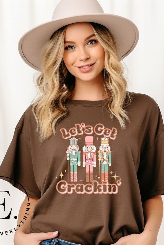 Get into the festive groove with our Christmas Nutcracker shirt that exclaims, "Let's Get Crackin'!" on a brown colored shirt. 