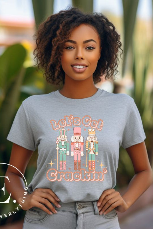 Get into the festive groove with our Christmas Nutcracker shirt that exclaims, "Let's Get Crackin'!" on a grey colored shirt. 