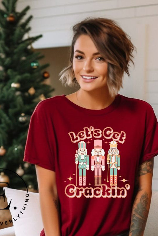 Get into the festive groove with our Christmas Nutcracker shirt that exclaims, "Let's Get Crackin'!" on a cardinal colored shirt. 