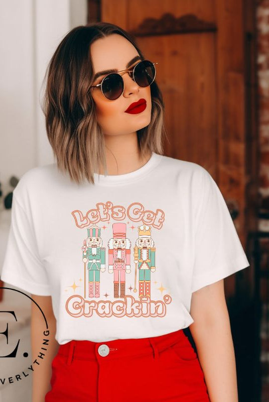 Get into the festive groove with our Christmas Nutcracker shirt that exclaims, "Let's Get Crackin'!" on a white colored shirt. 