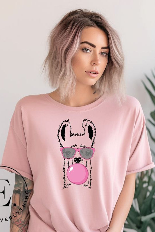 Llama wearing pink sunglasses blowing a bubble gum bubble on a pink colored shirt.