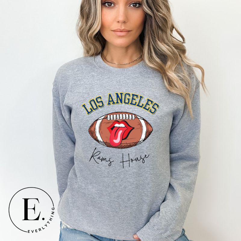 Cheer on the Los Angeles Rams in style with our exclusive sweatshirt featuring the team name and iconic slogan, "Ram House." On a grey sweatshirt. 