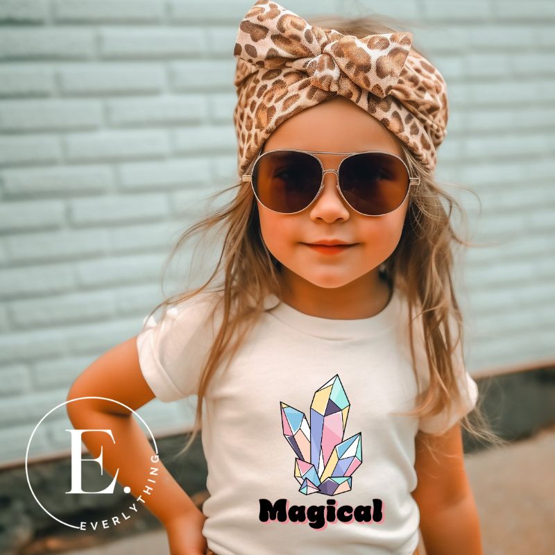 Our kids' shirt is designed to unleash your child's magic. Featuring colorful crystals and the word "Magical", it ignites your child's imagination on a white shirt. 