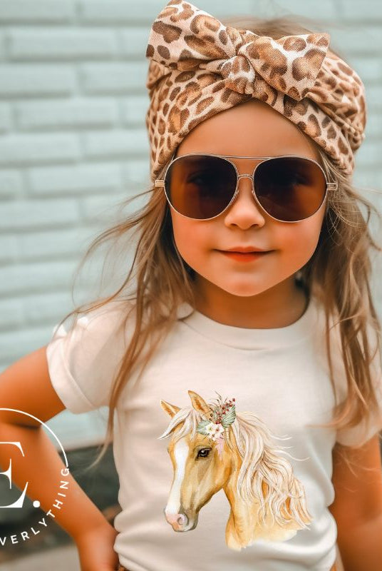 Embrace the equestrian vibe with our kids' shirt which features a majestic horse head adorned with a beautiful floral arrangement on its mane on a white shirt. 