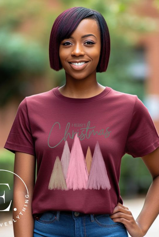 Get into the holiday spirit with our modern minimalist Christmas t-shirt. It features charming pastel Christmas trees with a sleek "Merry Christmas" message above the trees, perfectly blending simplicity and festive cheer on a maroon shirt. 