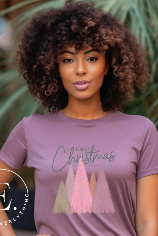 Get into the holiday spirit with our modern minimalist Christmas t-shirt. It features charming pastel Christmas trees with a sleek "Merry Christmas" message above the trees, perfectly blending simplicity and festive cheer on a purple shirt. 