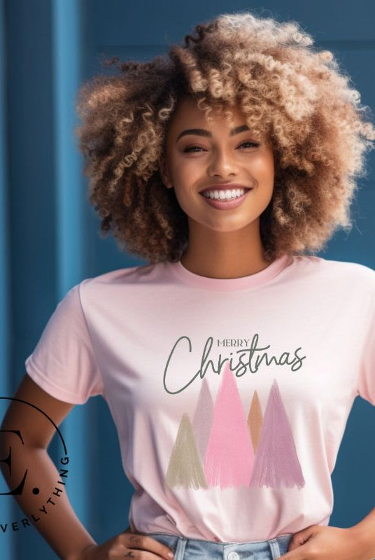 Get into the holiday spirit with our modern minimalist Christmas t-shirt. It features charming pastel Christmas trees with a sleek "Merry Christmas" message above the trees, perfectly blending simplicity and festive cheer on a pink shirt. 