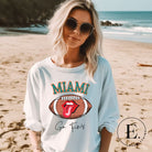 Show off your Miami Dolphins pride with this eye-catching sweatshirt, boasting a football and playful lips and tongue design. Highlighted with the team's motivating slogan "Go Fins" and the iconic Miami wordmark, on a white sweatshirt.