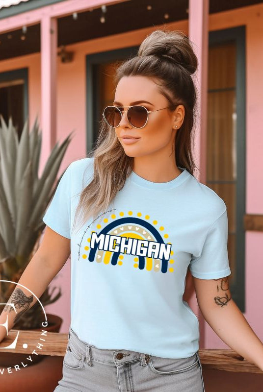 Unleash your vibrant spirit with our Michigan graphic tee. Adorned with a rainbow in school colors and "Michigan" in playful block bubble lettering, this shirt exudes energy and Wolverine pride on a ice blue shirt. 