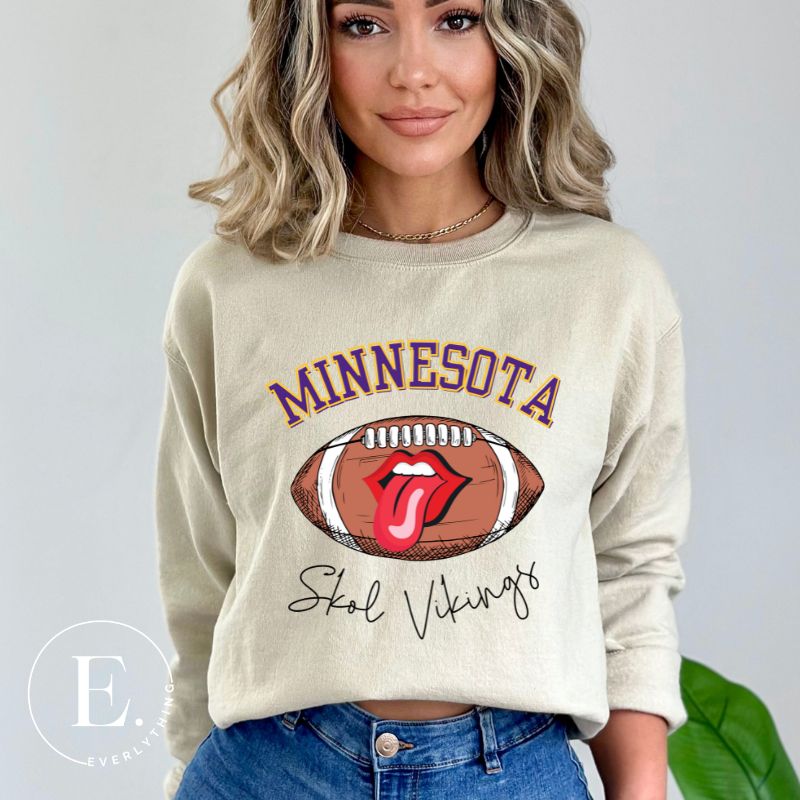Elevate your game-day look with this Minnesota Viking sweatshirt, featuring a football and unique lips and tongue design. Complete with the team's rallying cry " Skol Vikings" and the iconic Minnesota wordmark, on this sand colored sweatshirt. 