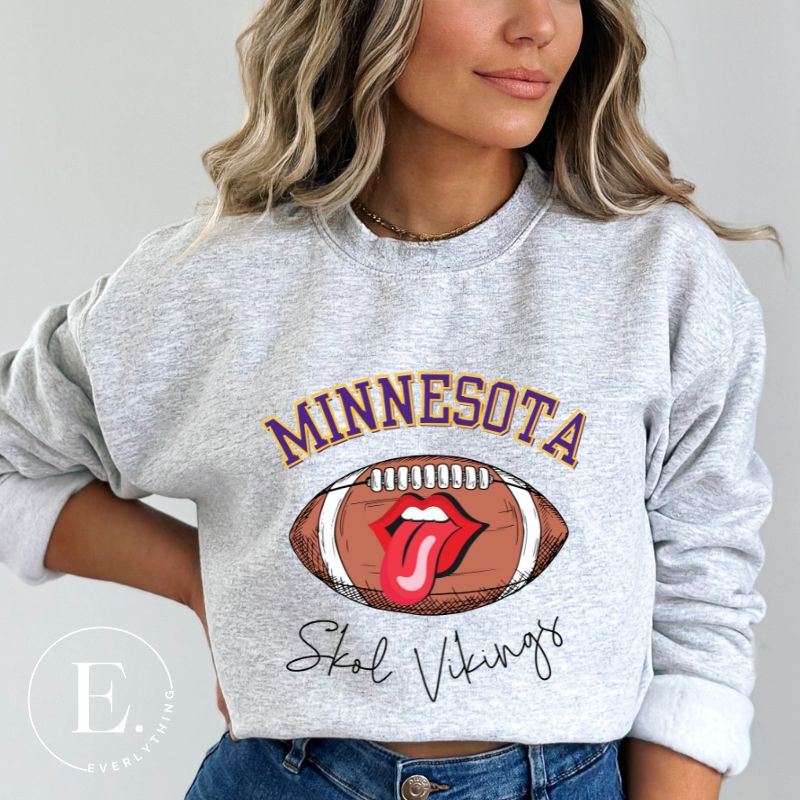 Elevate your game-day look with this Minnesota Viking sweatshirt, featuring a football and unique lips and tongue design. Complete with the team's rallying cry " Skol Vikings" and the iconic Minnesota wordmark, on this grey sweatshirt. 