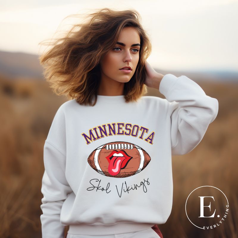 Elevate your game-day look with this Minnesota Viking sweatshirt, featuring a football and unique lips and tongue design. Complete with the team's rallying cry " Skol Vikings" and the iconic Minnesota wordmark, on this white sweatshirt. 
