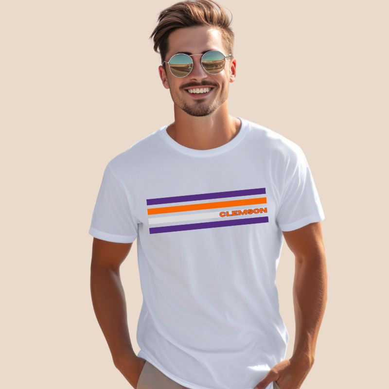 Bella + Canvas 3001 unisex T-shirt featuring a Clemson University design with purple, orange, and grey stripes and the word "Clemson" in bold orange letters on a white shirt