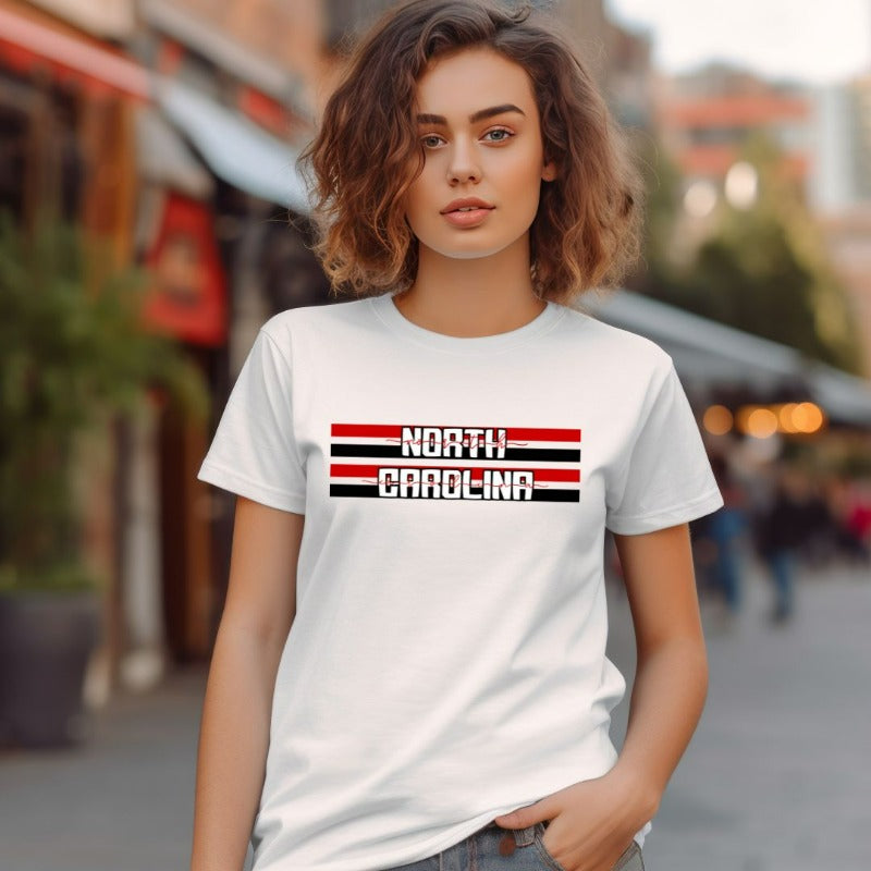 "North Carolina" in bold red and white text on a black and red striped background across the chest on a white shirt.