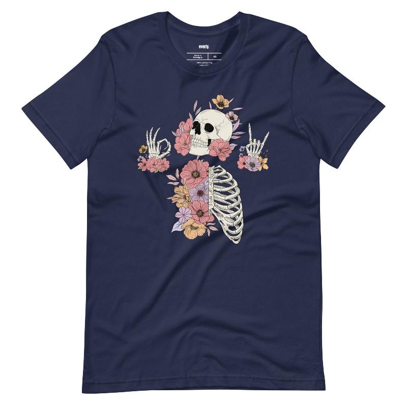 Navy t-shirt featuring a detailed skeleton design with ribcage and hands intertwined with soft, colorful flowers, blending gothic and floral aesthetics.