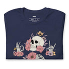 Navy t-shirt featuring a detailed skeleton design with ribcage and hands intertwined with soft, colorful flowers, blending gothic and floral aesthetics.