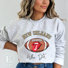 Get ready to represent the New Orleans Saints in style with this vibrant sweatshirt. Featuring a football and playful lips and tongue design, it proudly displays the team's iconic slogan "Who Dat" and the distinctive New Orleans wordmark on a grey sweatshirt. 