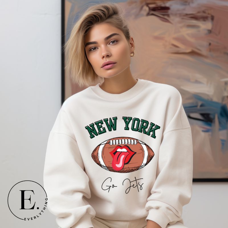 Gear up for game day with this New York Jets sweatshirt, featuring a football and playful lips and tongue design. Emblazoned with the team's rallying cry "Go Jets" and the iconic wordmark New York, on a white sweatshirt. 