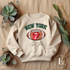 Gear up for game day with this New York Jets sweatshirt, featuring a football and playful lips and tongue design. Emblazoned with the team's rallying cry "Go Jets" and the iconic wordmark New York, on a sand colored sweatshirt. 