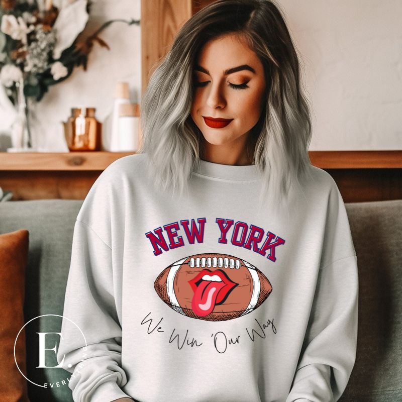 Elevate your game-day attire with this New York Giants sweatshirt, featuring a football and unique lips and tongue design. Highlighted with the team's empowering slogan "We Win Our Way" and the iconic New Yor wordmark, on a grey sweatshirt. 