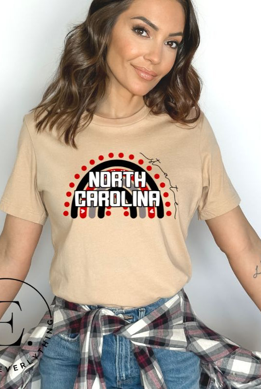 Looking for a way to show off your vibrant spirit? Look no further than this NC State University t-shirt. The NC State colors shine on a boho rainbow backdrop, representing the iconic North Carolina wordmark in a unique and trendy way on a tan shirt. 