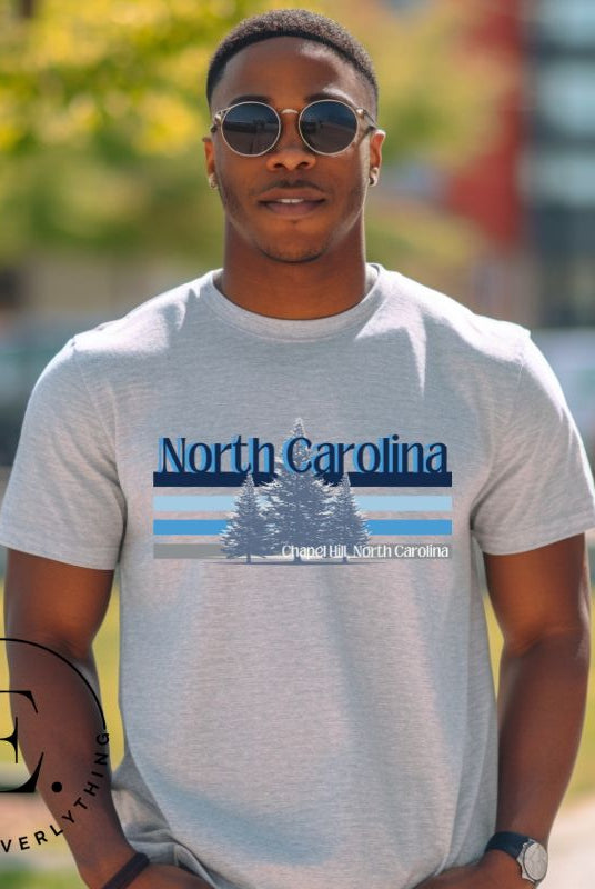 Show your school pride with this iconic North Carolina wordmark t-shirt. Made from premium materials, it features a North Carolina tree line in a the cool Carolina blue colors, representing a tradition of excellence for the nature that North Carolina offers on a grey shirt. 